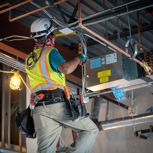 Close-up of electrician connecting wires inside a residential electrical breaker panel for safe power distribution.