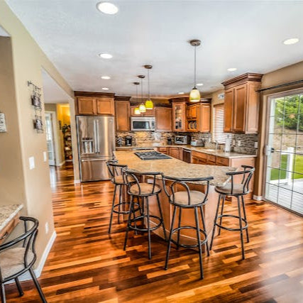 Spacious kitchen remodel with hardwood floors island and updated lighting