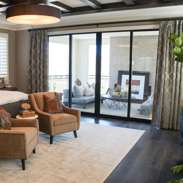 Patio sliding door installation with black framed glass panels connecting bedroom to outdoor balcony