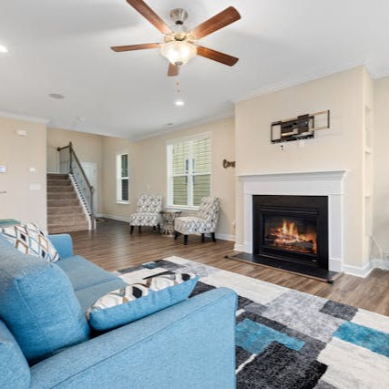 Living room with detailed crown molding, window trim, and custom built-in shelving around a fireplace in Denver home