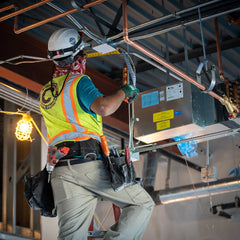 Close-up of electrician connecting wires inside a residential electrical breaker panel for safe power distribution.