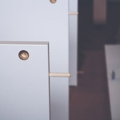 A handyman carefully assembling white furniture with a screwdriver, showcasing professional furniture assembly services for homeowners.