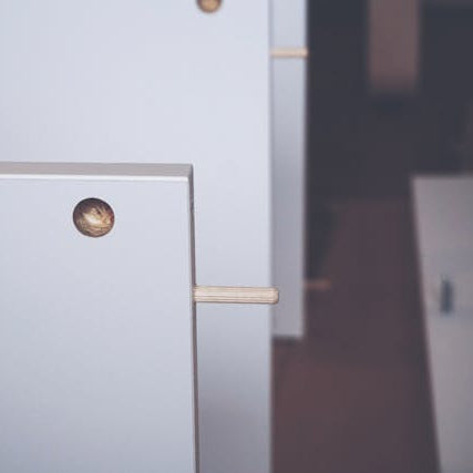 A handyman carefully assembling white furniture with a screwdriver, showcasing professional furniture assembly services for homeowners.