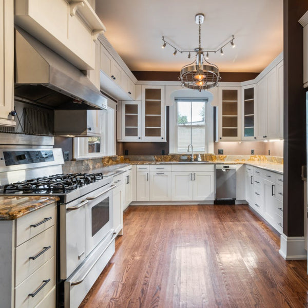 Kitchen renovation featuring white cabinets granite countertops stainless steel appliances and hardwood flooring