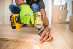 Close-up of handyman using yellow DEWALT drill during a home repair in Brighton, Colorado.

