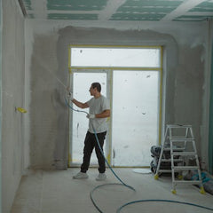 Handyman spraying drywall mud and applying wall texture during interior renovation in Thornton Colorado