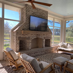Outdoor TV mounted above brick fireplace on covered patio in Brighton Colorado by Rocky Ridge Handyman