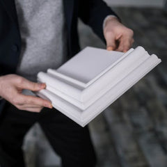 Handyman showing crown molding and baseboard trim samples for home installation in Colorado